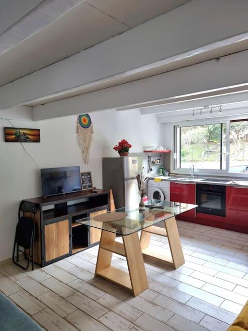 - une cuisine avec une table en verre dans une pièce dans l'établissement Loft studio avec mezzanine, limitrophe Monaco, à Roquebrune-Cap-Martin