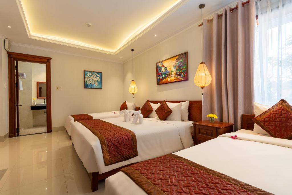 Postel nebo postele na pokoji v ubytování Iris De Villa Hoi An