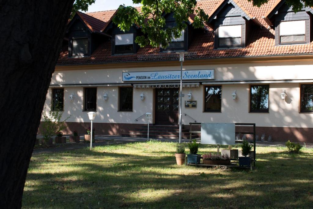 ein Gebäude mit einem Schild davor in der Unterkunft Pension Lausitzer Seenland in Elsterheide