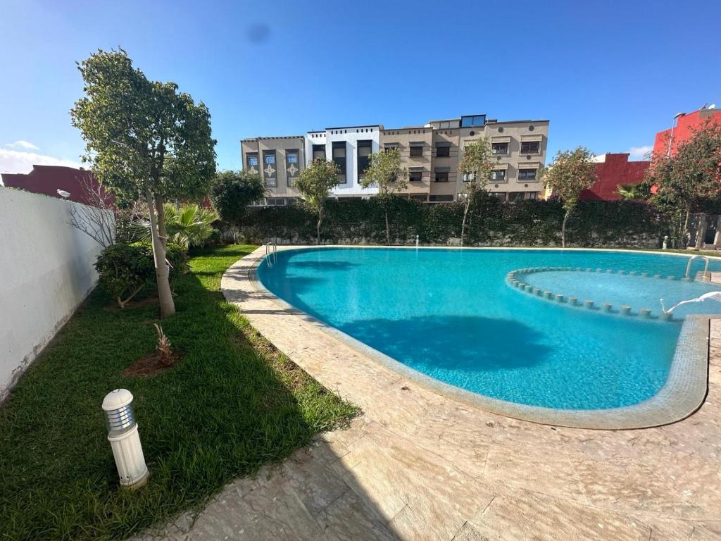 a large blue swimming pool in front of a building at Résidence Les Jardins Du Mazagan in El Jadida