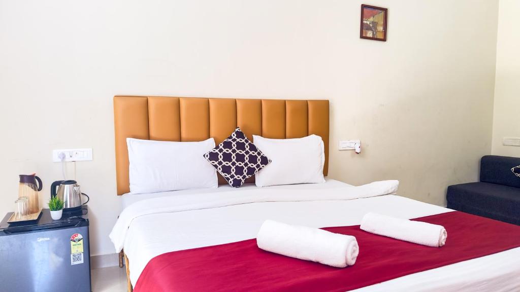 a bedroom with a large bed with two pillows at Hotel Leela Inn Candolim in Marmagao