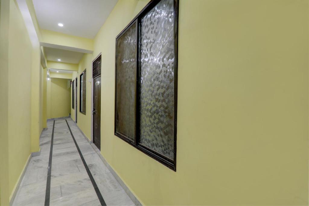 a hallway with yellow walls and paintings on the wall at Prayag Hotel & Restaurent in Naini