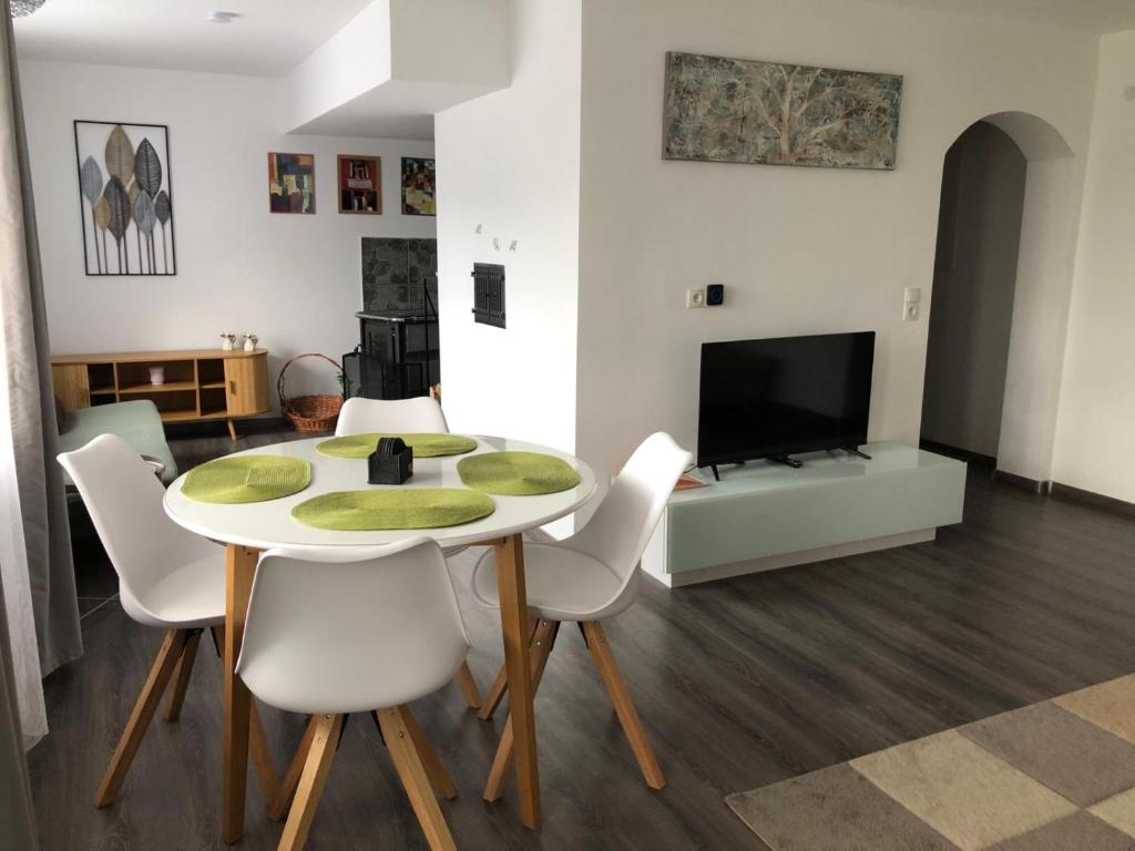 a living room with a table and chairs and a tv at Einliegerwohnung in Gissigheim in Königheim