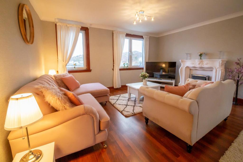 a living room with two couches and a fireplace at 2 wheelhouse apartments in Lochinver