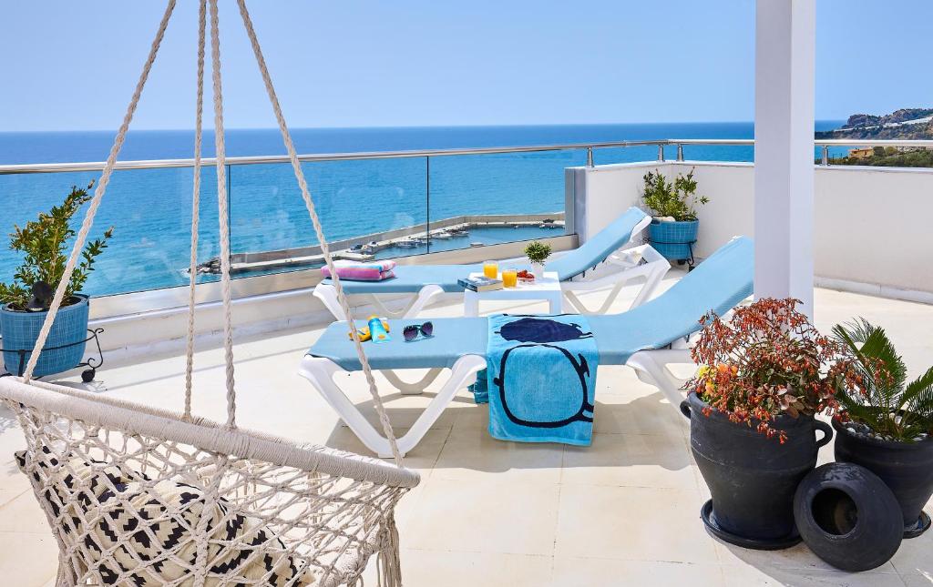 a balcony with chairs and a pool on a boat at Breathtaking sea view flat for families in Crete in Keratokampos