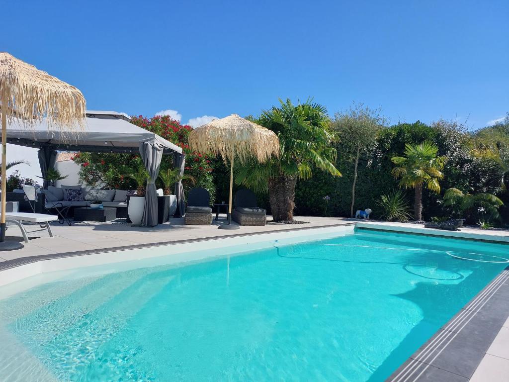 a swimming pool with blue water in a resort at Aix'capade by Aixkeys avec piscine 5 min plages Fouras in Saint-Laurent-de-la-Prée