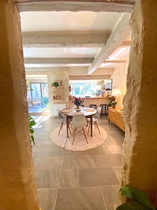 un salon avec une table et une cuisine dans l'établissement Maison de Ville au centre historique d’Uzès, à Uzès
