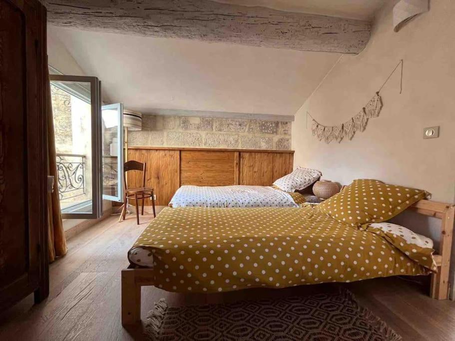 een slaapkamer met een groot bed met polka dot-lakens bij Maison de Ville au centre historique d’Uzès in Uzès