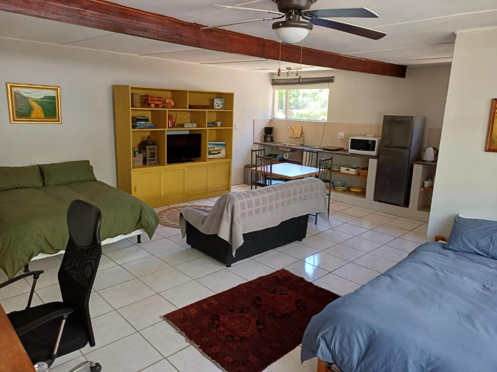 a living room with two beds and a kitchen at Lemon Tree Cottage Noordhoek in Cape Town