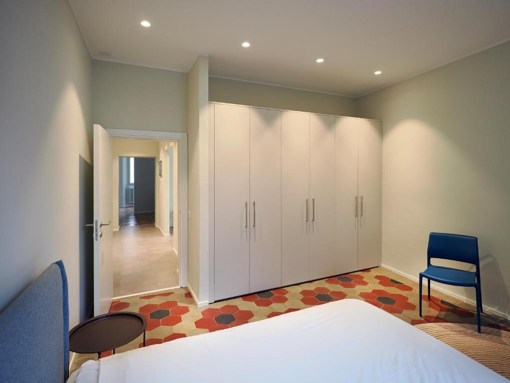 1 dormitorio con 1 cama y 1 silla azul en Appartamento Festival 8 en Muralto