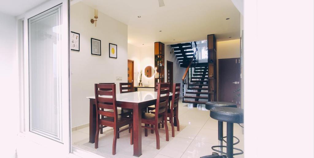 a kitchen and dining room with a table and chairs at Mountain View Villa in Mukkam