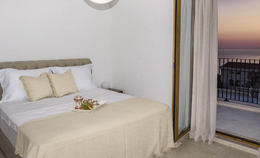 ein Schlafzimmer mit einem Bett und einem großen Fenster in der Unterkunft Belsize Villas in Budva