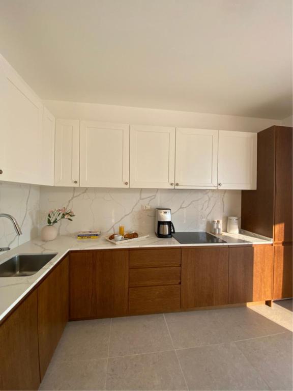 eine Küche mit weißen Schränken und einer Kaffeemaschine auf der Theke in der Unterkunft Belsize Villas in Budva