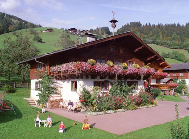 eine Gruppe von Menschen, die vor einem Gebäude sitzen in der Unterkunft Haus Katharina in Wagrain