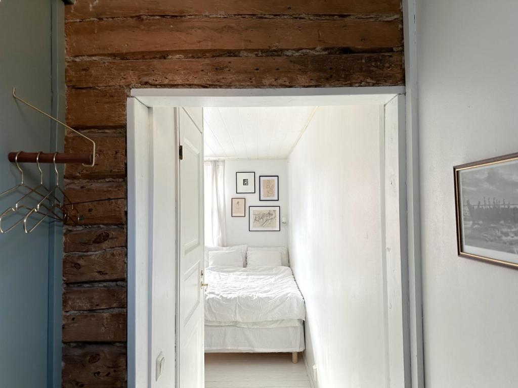 a bedroom with a bed in a white room at Wooden house studio with shared garden in Helsinki