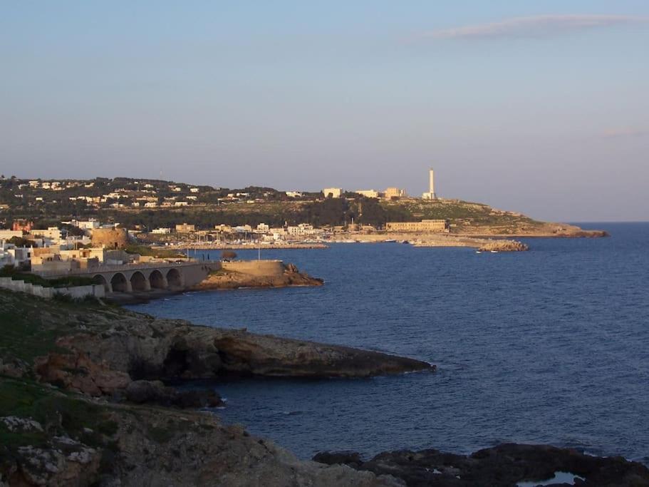 a large body of water with a town in the distance at Leukos in Leuca