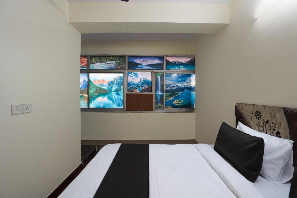a bed in a room with paintings on the wall at Super Collection O Hotel SPS in Ghaziabad