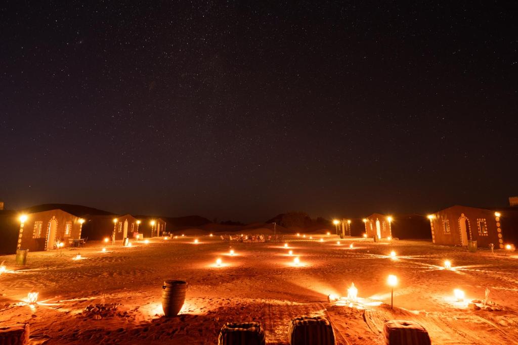 Una calle de noche con muchas luces en Taragalte Nomad Camp, en Mhamid