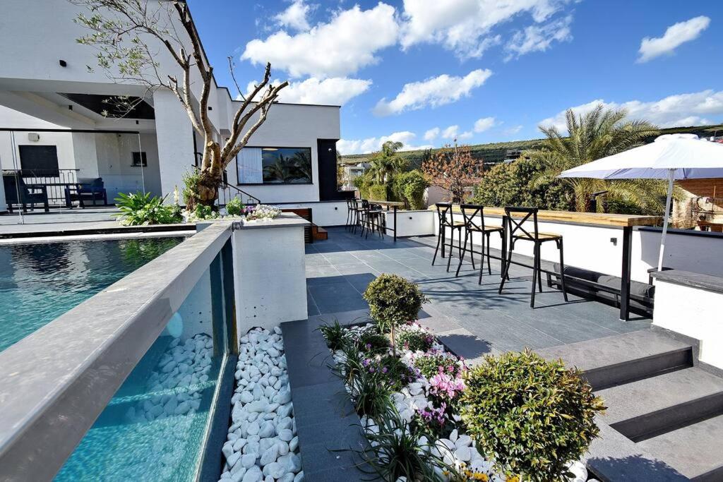 a house with a swimming pool and a table and chairs at וילה אליה in Migdal