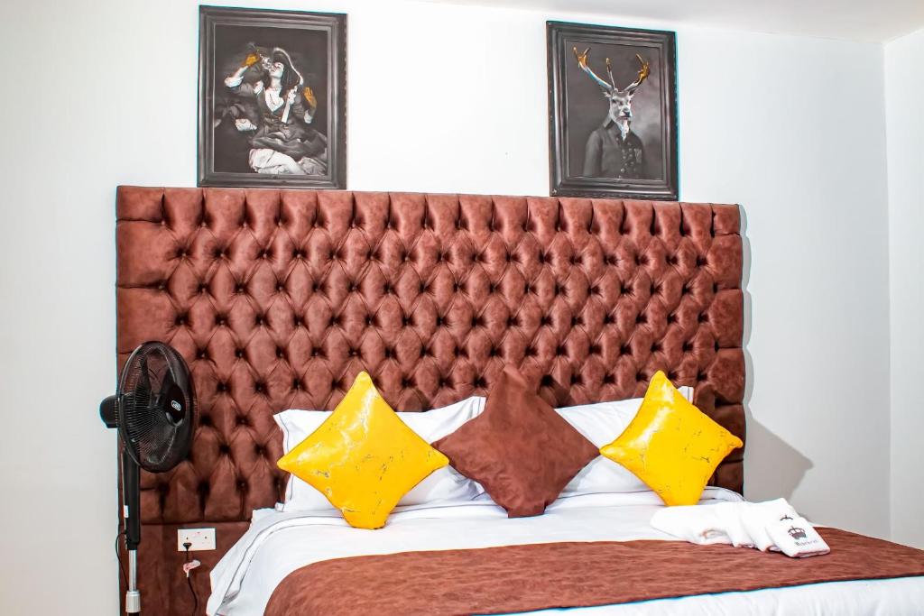 um quarto com uma cama grande e almofadas amarelas em Luxury 3 Bedroom Self Catering Apartment- Masvingo em Masvingo