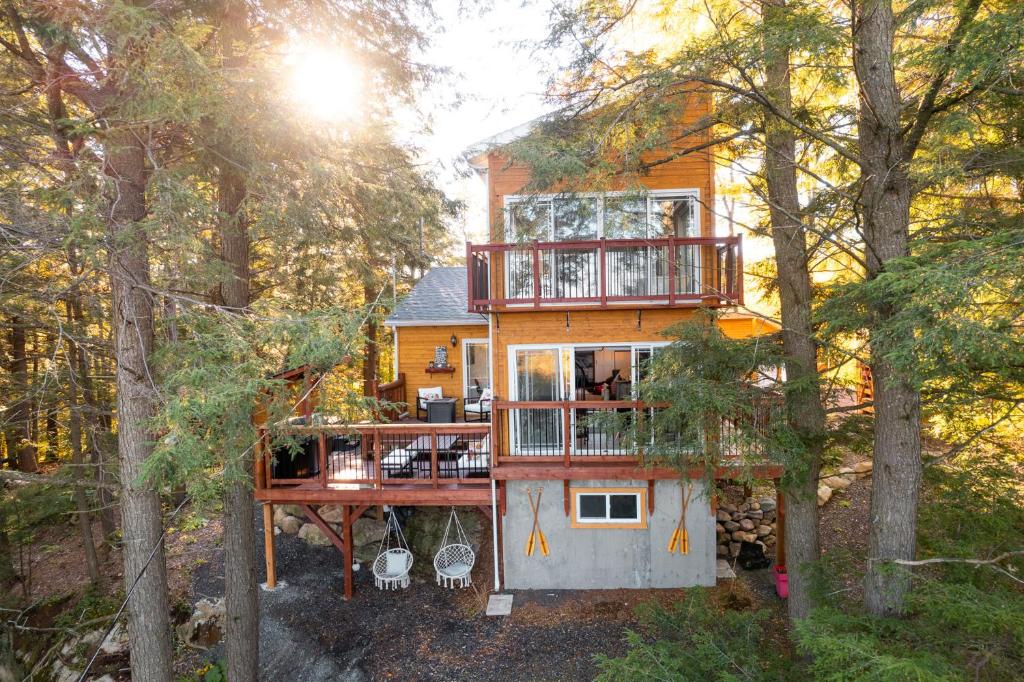 a house in the middle of a forest at LoveNestChalet - Hot tub & Fireplace - Warm, cozy & relaxing in Grenville-sur-la-Rouge