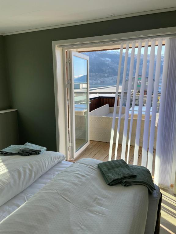 a bedroom with two beds and a large window at Toppleiligheit - Eidsgata 49 in Nordfjordeid