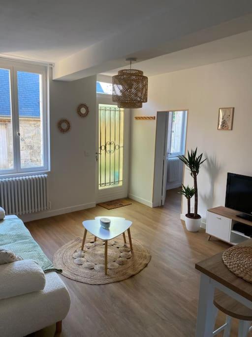 un salon avec un canapé et une table basse dans l'établissement Maison de charme, à Ambleny