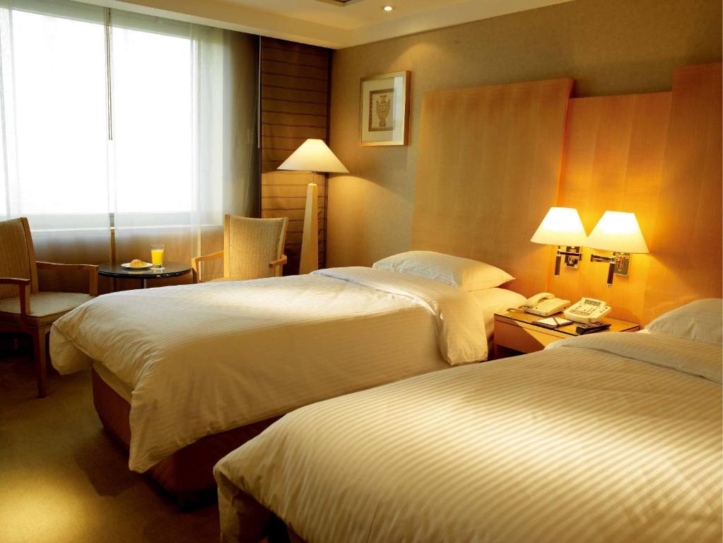 Postel nebo postele na pokoji v ubytování Daegu Grand Hotel