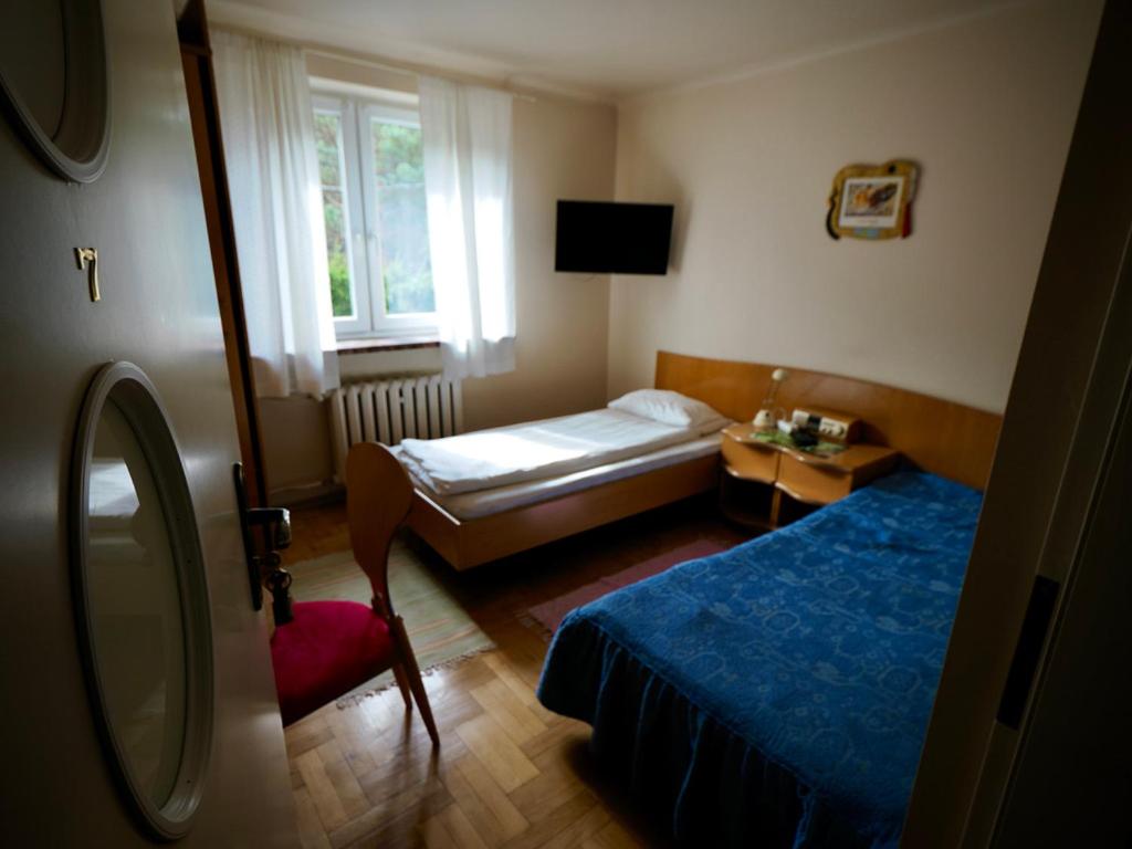um pequeno quarto com uma cama e uma janela em Villa Romano em Kielce