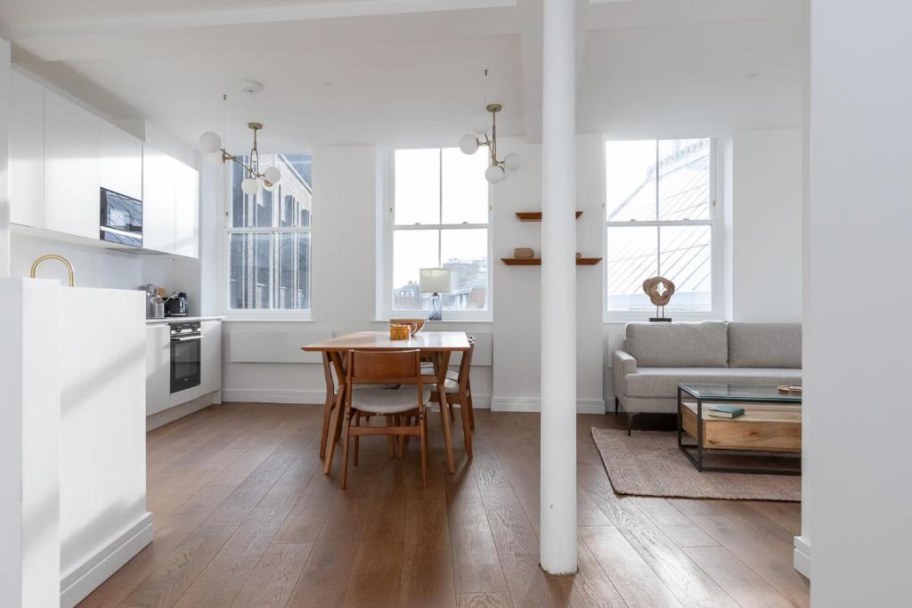 a kitchen and living room with a table and a couch at Splendid 2 Bedroom Duplex Holborn london in London