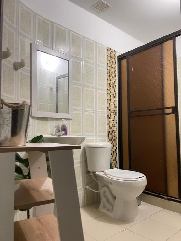 bagno con servizi igienici, lavandino e specchio di Apartamento moderno cerca al aeropuerto a Neiva