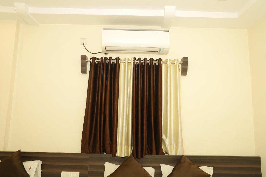 a room with a curtain and a light above a bed at Hotel Sai hiira in Rewa