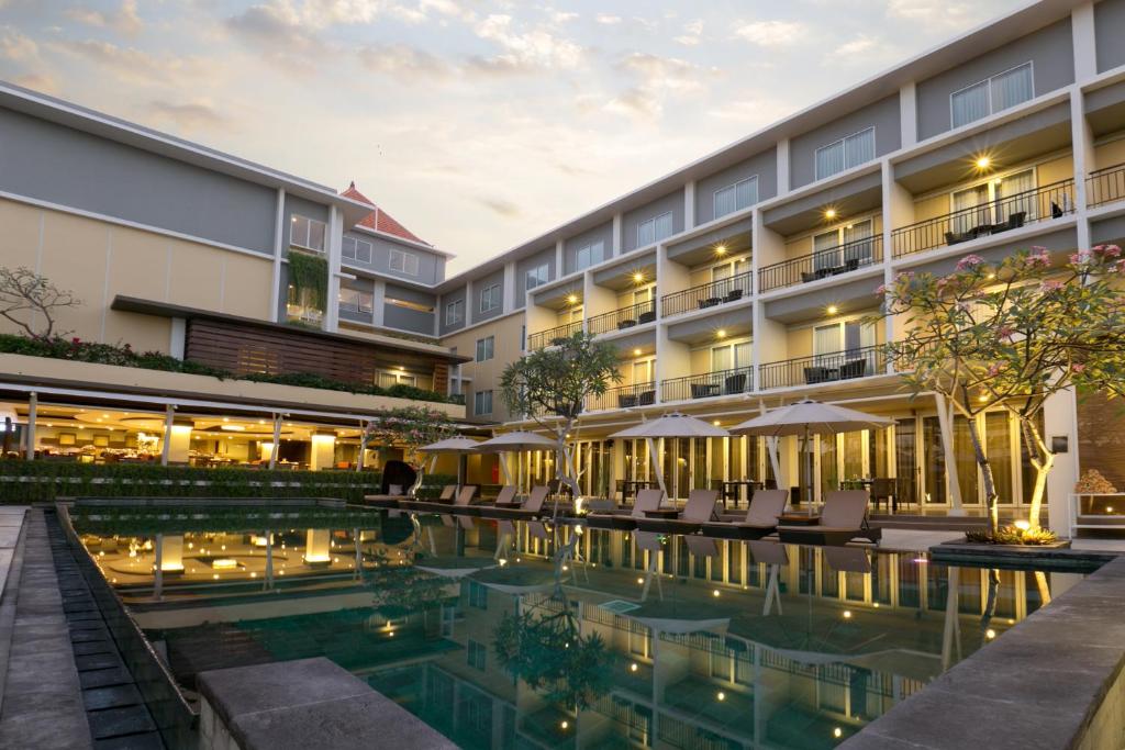 
a large swimming pool in a large building at The Kana Kuta Hotel in Kuta
