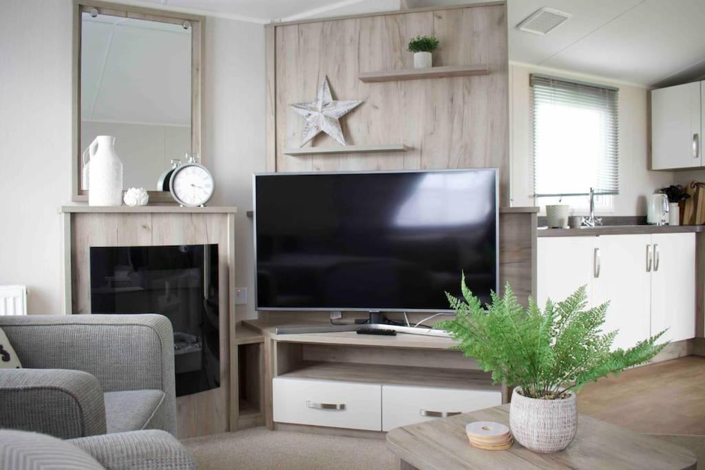 a living room with a large flat screen tv at Scottish Holiday Home in Ardeer Square