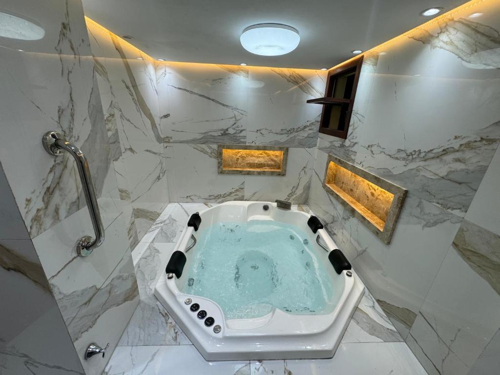 une salle de bains avec un jacuzzi au milieu dans l'établissement Solar de Pipa Vip Confort - Spa Hidro Flat, à Pipa