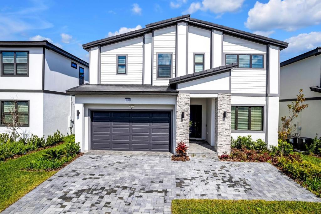 a white house with a garage at Orlando's Best Escape Residence at Paradiso Grande Resort home in Orlando