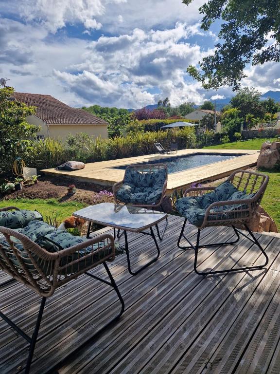 - deux chaises et une table sur une terrasse à côté de la piscine dans l'établissement casasantellix, à Prunelli-di-Fiumorbo