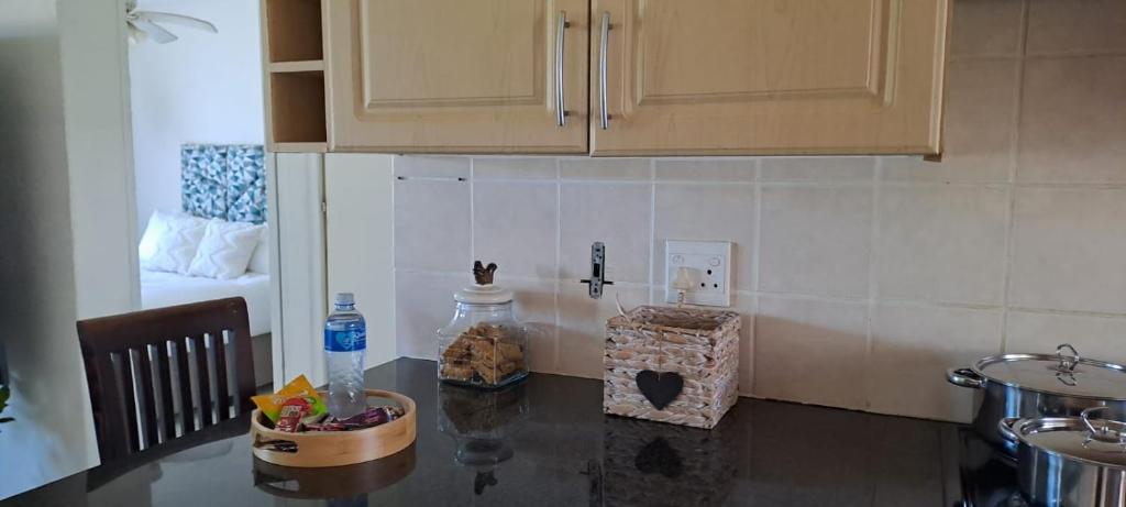 a kitchen with a counter top and a table with a bowl of food at 18 Key Largo Ocean House of Uzurie in Kingsburgh