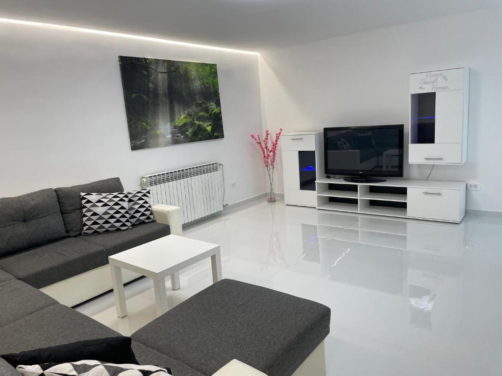 a living room with a couch and a tv at Apartment White Zagreb - private parking&garage in Zagreb