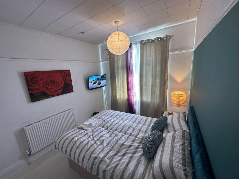 a bedroom with a bed and a lamp and a window at Private Room 1 Near Southmead Hospital, Bristol in Bristol