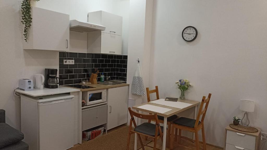 a small kitchen with a table and a table and chairs at M&M Apartment Budapest House in Budapest