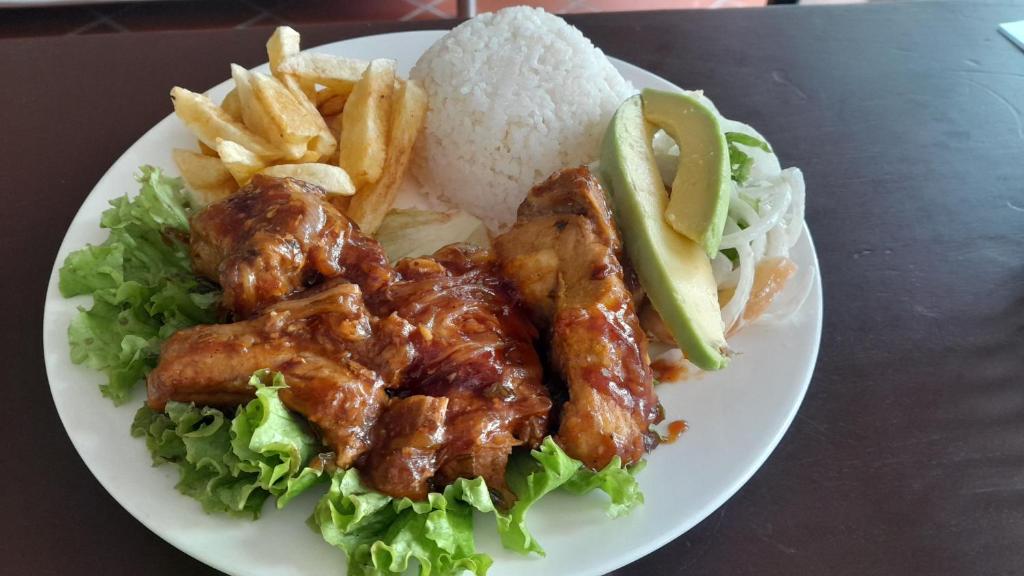 a plate of food with chicken lettuce and french fries at Cabañas LLano Lindo Apiay in Villavicencio
