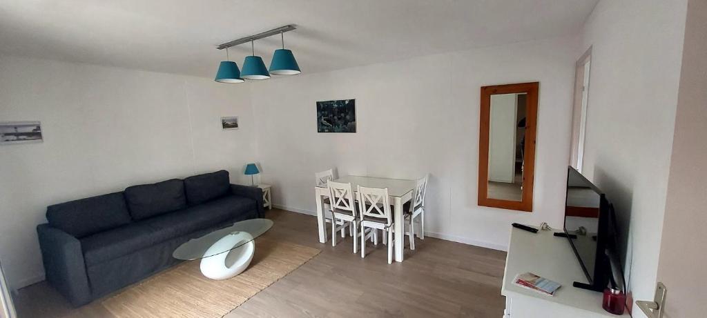- un salon avec un canapé bleu et une table dans l'établissement chalet Le Ticaco Soustons plage, à Soustons