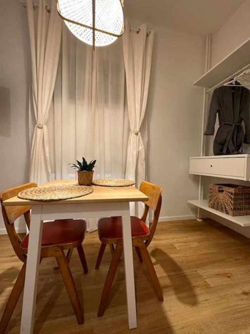 einem Esstisch mit 2 Stühlen und einem Tisch mit einer Pflanze in der Unterkunft Magnolia Studio in Radomlje
