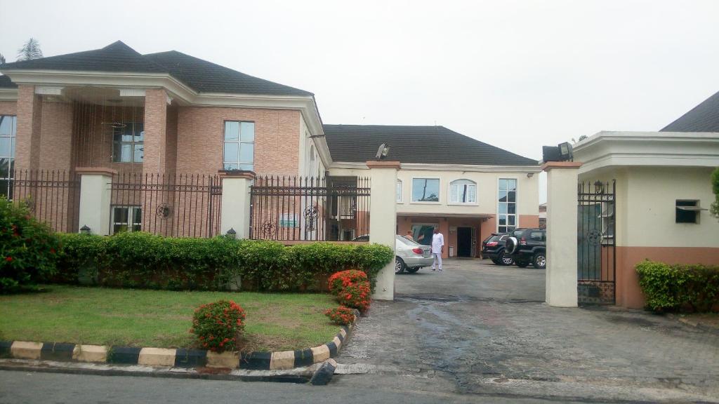 a house with a fence and a driveway at Petesville Hotel Limited in Calabar