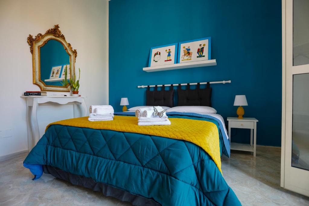ein blaues Schlafzimmer mit einem Bett und einem Spiegel in der Unterkunft Biddizzi in Palermo
