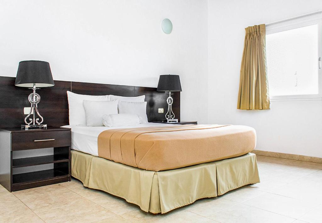 sypialnia z dużym łóżkiem z 2 lampami w obiekcie Hotel Kariña Maturín w mieście Maturín