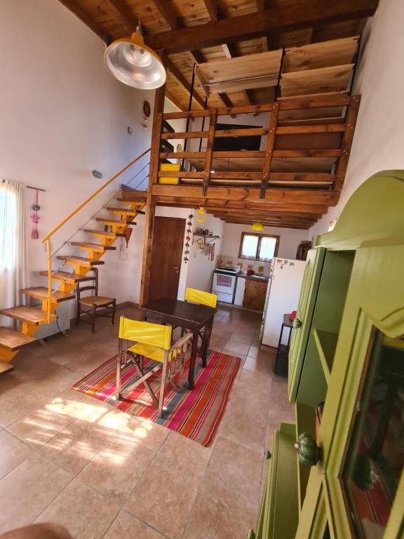 a living room with a table and a staircase at Casita Alegre in Cafayate