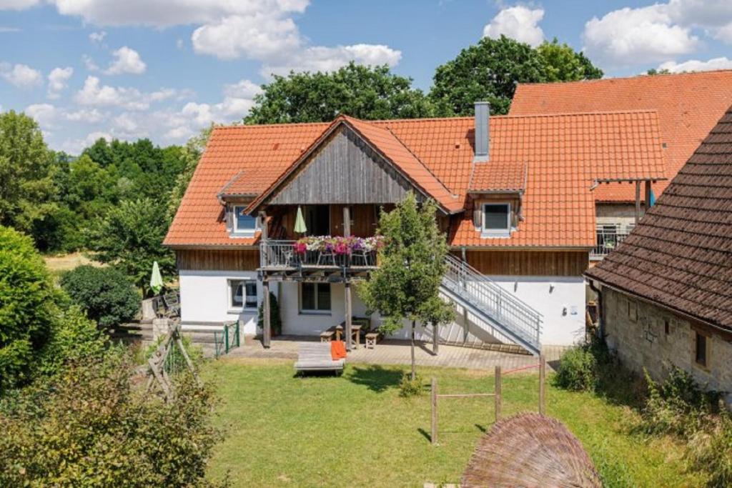 a house with an orange roof and a yard at KrämersBug - Unterkunft für Familien mit kleinen Kindern in Simmershofen