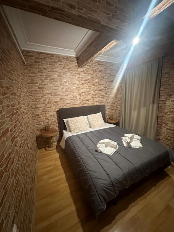 een slaapkamer met een bed en een bakstenen muur bij The cave in Athene